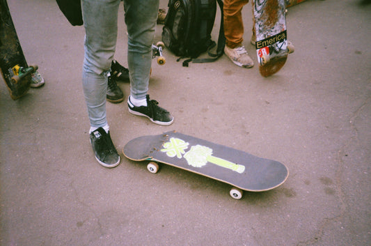 Person standing next to their broken skateboard